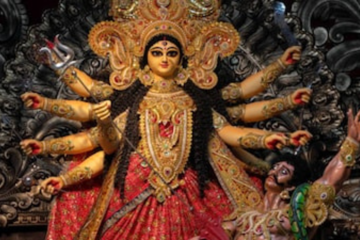 Goddess Durga idol with devotees chanting Durga Chalisa with diya and flowers in temple